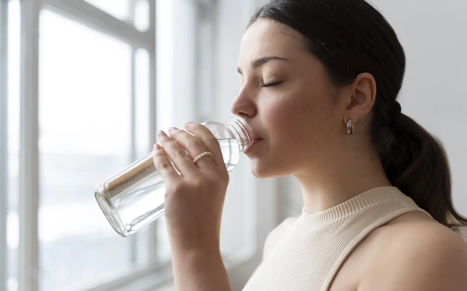 Девушка пьет воду.