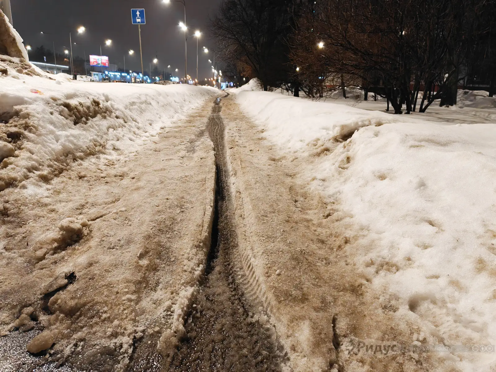 Колея, накатанная курьерскими электро-скутерами на пешеходном тротуаре, г. Москва. 
