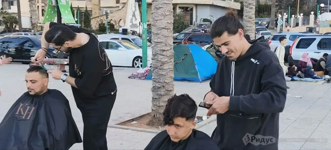 Бейрут, парикмахеры бесплатно стригут беженцев на набережной. Бейрут, парикмахеры бесплатно стригут беженцев на набережной. 