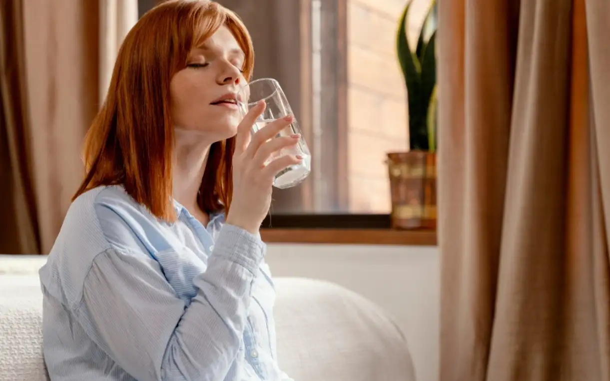 Девушка пьет воду.